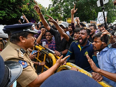 University students speak with a police officer during a demonstration against the economic crisis near the parliament building in Colombo on May 4, 2022.