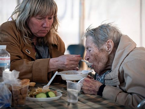 People have a meal after arriving from the Ukrainian city of Mariupol at a center for displaced people in Zaporizhzhia, Ukraine, Tuesday, May 3, 2022.