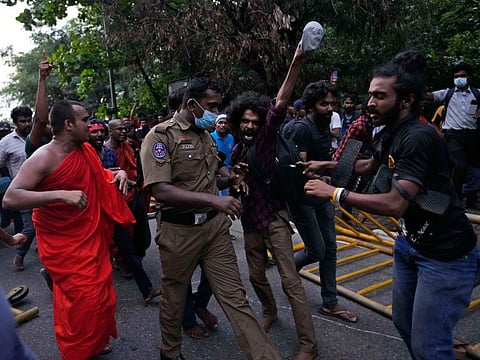 Sri Lankan students confront a police officer during a protest outside parliament in Colombo, Sri Lanka, Thursday, May 5, 2022.