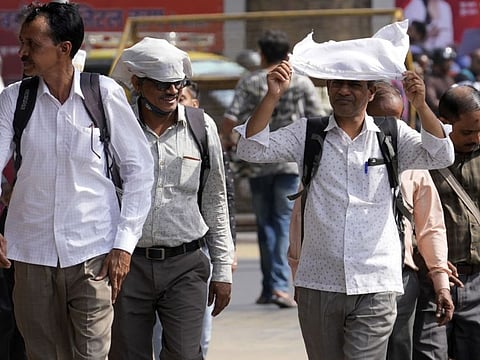 People walk on a Mumbai street on May. 7, 2022. 