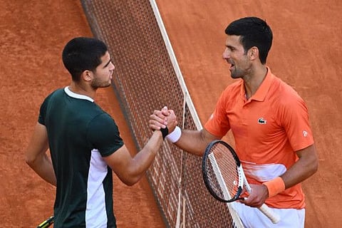 Spain's Carlos Alcaraz (left) and Serbia's Novak Djokovic shake hands at the end of their 2022 ATP Tour Madrid Open tennis tournament men's singles semi-final match at the Caja Magica in Madrid.