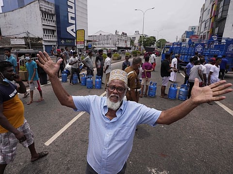 A Sri Lankan man shouts in jubilation after a truck carrying cooking gas arrived at a distribution centre in Colombo, Sri Lanka, Sunday, May 8, 2022. Diplomats and rights groups expressed concern Saturday after Sri Lankan President Gotabaya Rajapaksa declared a state of emergency and police used force against peaceful protesters amid the country's worst economic crisis in recent memory.