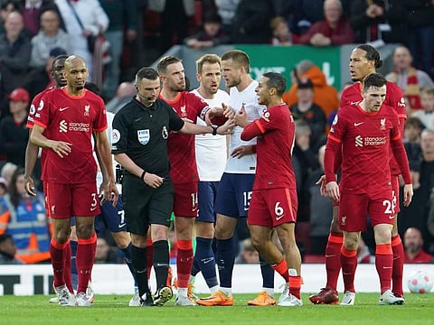 Liverpool and Tottenham Hotspur players argue with referee Michael Oliver during the English Premier League match at Anfield stadium in Liverpool, England. Liverpool face Aston Villa tomorrow in a match they need to win to keep their title hopes alive.