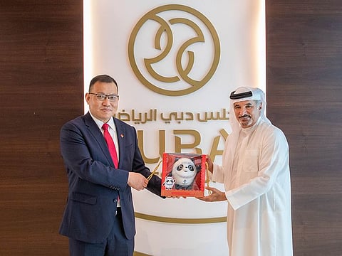 Saeed Hareb receives the mascot for the 2022 Winter Olympics from the head of the Chinese delegation.