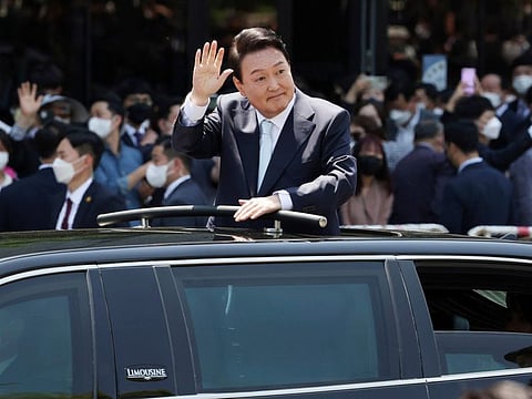 South Korea's new President Yoon Suk Yeol waves from a car after the Presidential Inauguration outside the National Assembly in Seoul, on May 10, 2022. 