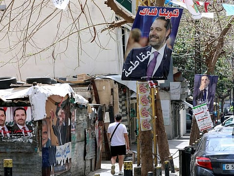 A man walks past posters depicting Lebanon's former Prime Minister Saad Hariri, ahead of the parliamentary election on May 15, in Beirut.