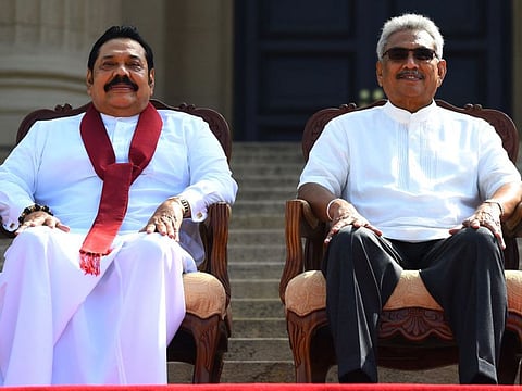 In this file photo taken on November 22, 2019, Sri Lanka's President Gotabaya Rajapaksa (right) and his Prime Minister brother Mahinda Rajapaksa, pose for a photograph after the ministerial swearing-in ceremony in Colombo. 