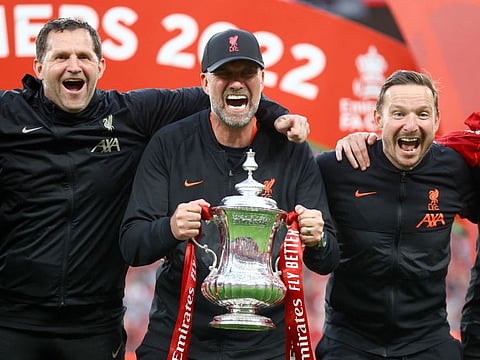 Liverpool manager Juergen Klopp and his coaching team celebrate with the FA Cup trophy after beating Chelsea at Wembley Stadium in the final.