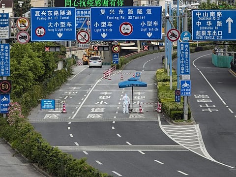 A police officer in personal protective equipment (PPE) stands guard at a checkpoint during a lockdown due to Covid-19 in Shanghai, China, on Monday, May 16, 2022.