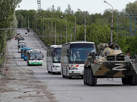 Buses carrying Ukrainian soldiers who have surrendered being driven away under escort of the pro-Russian military in Mariupol on May 17, 2022. 