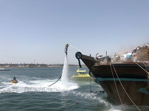 Firefighters try to douse the flame on the wooden dhow at Hamriya Port in Dubai today. 