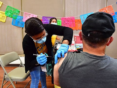Registered Nurse Mariam Salaam administers the Pfizer booster shot at a vaccination and testing site at Ted Watkins Park in Los Angeles on May 5, 2022. Some experts are worried the country now is seeing signs of a sixth wave, driven by an Omicron subvariant.