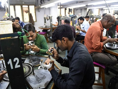 Indian workers examine diamond stones at a diamond cutting and polishing workshop in Ahmedabad.  