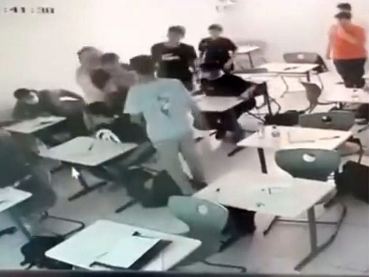  The teacher (left) trying to save the student who swallowed a piece of plastic.