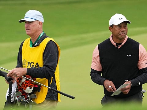 Tiger Woods and caddie Joe LaCava walk off the 18th green after finishing the third round of the PGA Championship at Southern Hills Country Club.