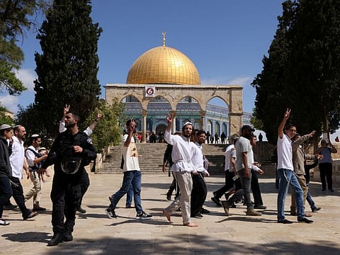 Jewish visitors gesture as Israeli security forces secure the area at the compound that houses Al Aqsa Mosque, known to Muslims as Noble Sanctuary and to Jews as Temple Mount, in Jerusalem's Old City, May 5, 2022. 