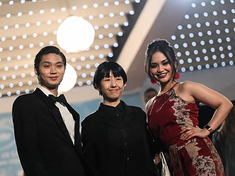 Japanese actor Hayato Isomura, Japanese director and screenwriter Chie Hayakawa and Filipino actress Stefanie Arianne pose as they arrive for the screening of the film 'Plan 75' at the 75th edition of the Cannes Film Festival 