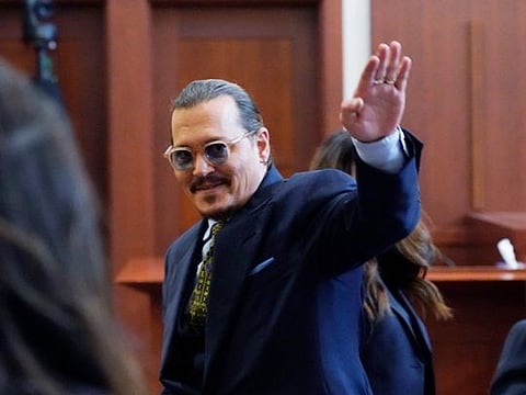 Actor Johnny Depp gestures to the gallery in the courtroom as he leaves for the day at the Fairfax County Circuit Courthouse in Fairfax, Va., Monday, May 23, 2022. Depp sued his ex-wife Amber Heard for libel in Fairfax County Circuit Court after she wrote an op-ed piece in The Washington Post in 2018 referring to herself as a "public figure representing domestic abuse." (AP Photo/Steve Helber, Pool)
