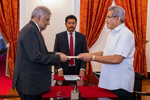 In this handout photograph taken and released by Sri Lanka's President's Office on May 25, 2022, Sri Lanka's President Gotabaya Rajapaksa (R) swears-in Prime Minister Ranil Wickremesinghe (L) as the new Finance Minister, in Colombo.
