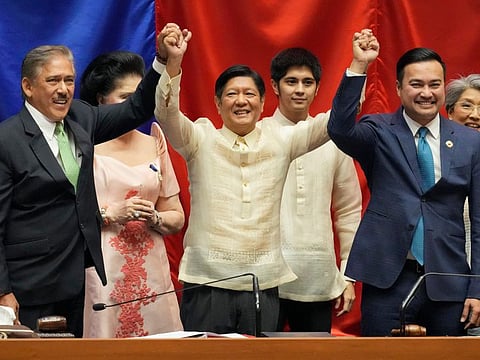 President-elect Ferdinand ‘Bong” Marcos Jr., centre, raises hands with Senate President Vicente Sotto III, left, and House Speaker Lord Allan Velasco during his proclamation at the House of Representatives, Quezon City, Philippines on Wednesday, May 25, 2022.