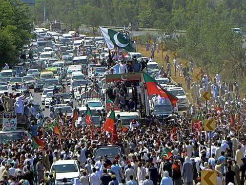 Pakistan's former prime minister Imran Khan (on the vehicle) along with supporters take part in a rally in Swabi on May 25, 2022. 