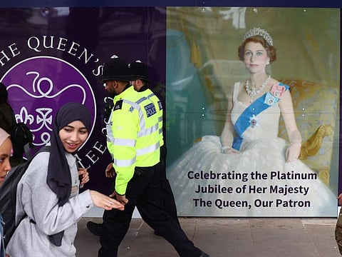 Members of the public walk past a display celebrating the Platinum Jubilee of Britain's Queen Elizabeth II, outside the Royal United Services Institute in London, on May 26, 2022.
