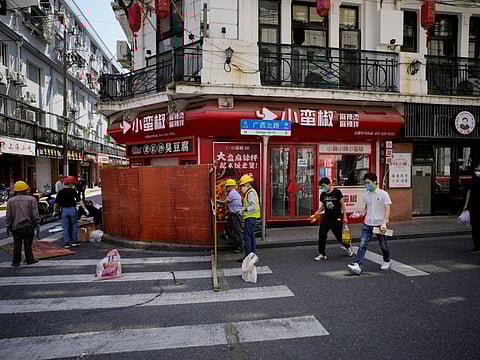 Workers dismantle barriers at a residential area, as the city prepares to end the lockdown in Shanghai on May 31, 2022. 