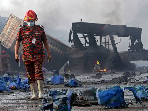 A firefighter stands amid the debris at the site where a fire that broke out at a container storage facility in Sitakunda, about 40 km (25 miles) from the key port of Chittagong on June 5, 2022