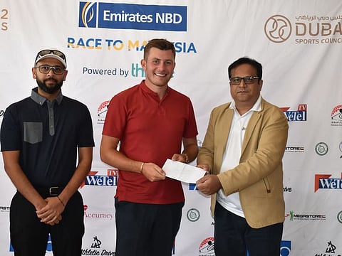 Ted Speller (centre), winner of Division 1 in last Emirates NBD Race to Malaysia qualifier, flanked by sponsors, Adil Matin (right) of WeTel TV and Clyde Mirangi of Emirates NBD.
