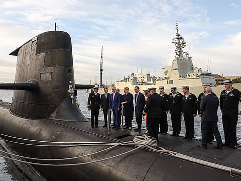 This file photo taken on May 2, 2018 shows French President Emmanuel Macron (2nd L) and Australian Prime Minister Malcolm Turnbull (3rd L) standing on the deck of HMAS Waller, a Collins-class submarine operated by the Royal Australian Navy, at Garden Island in Sydney.