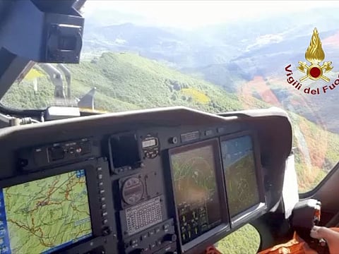 A Italian firefighter helicopter searches the site of a helicopter crash in central Italy, on June 11, 2022.  