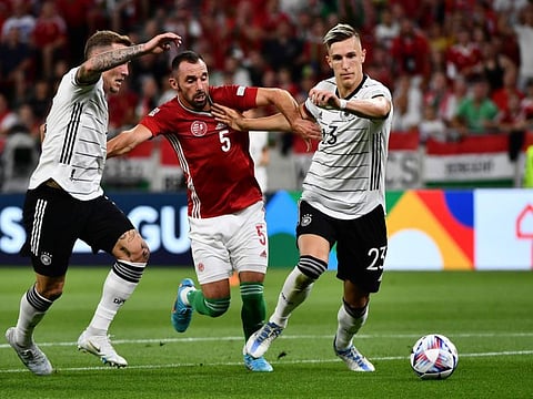 Hungary's Attila Fiola (centre) duels for the ball with Germany's Nico Schlotterbeck (right) during the UEFA Nations League soccer match at Puskas Arena in Budapest, Hungary.