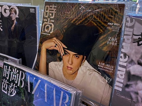 A fashion magazine showing Chinese-Canadian singer Kris Wu, center, on display for sale on a bookshelves at a convenience store in Beijing on July 20, 2021. Wu has faced rape and other criminal charges at a closed trial in Beijing. 