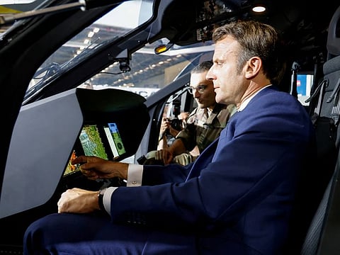 French President Emmanuel Macron looks at control monitors as he sits in the pilot's seat of an Airbus H160M Guepard helicopter during a visit to the Eurosatory land and airland defence and security trade fair, at the Paris-Nord Villepinte Exhibition Centre in Villepinte, north of Paris, on June 13, 2022.