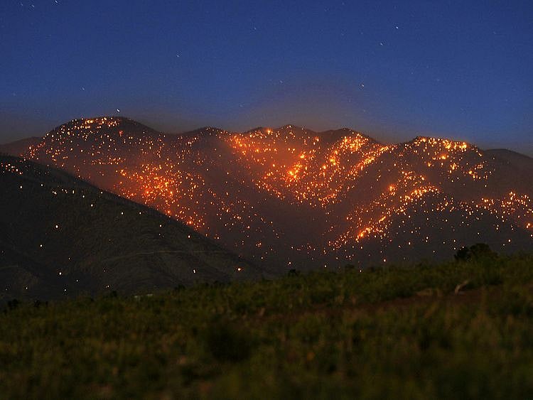 The Pipeline Fire leaves the mountains northeast of the San Francisco Peaks glowing with thousands of spot fires north of Flagstaff, Arizona, US.