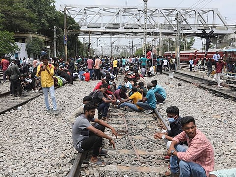Protesters sit on railway tracks at Secundrabad railroad station in Hyderabad, India, Friday, June 17, 2022 as a backlash continued for a second straight day Friday against a new short-term government recruitment scheme for the military.
