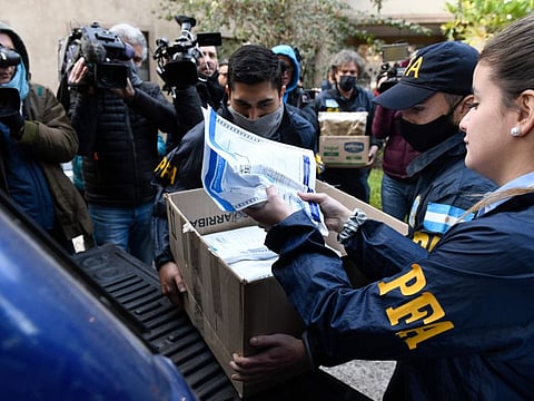 Police officers confiscate a box of documents during a judicial raid at the Plaza Central Hotel where the crew of a Venezuelan-owned Boeing 747 cargo plane are staying, in Buenos Aires. Argentine officials are trying to determine what to do with the cargo plane loaded with automotive parts and an unusually large crew of 17, including at least five Iranians.  