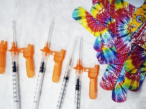 Syringes and colorful bandages are prepared as children from local schools prepare to get COVID-19 vaccines in Pittsfield, Mass., on Monday Dec. 13, 2021.