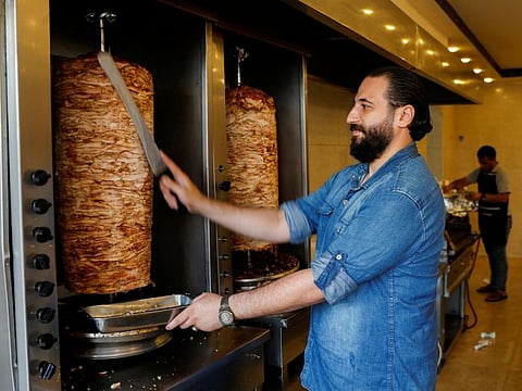 Syrian refugee Anas Qaterji works in his restaurant in Gaza City June 16, 2022.