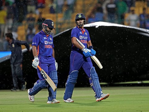 India's Rishabh Pant and teammate Shreyas Iyer walk back to the pavilion because of a halt in play due to rain during the 5th and final T20 cricket match at M Chinnaswamy Stadium in Bengaluru.