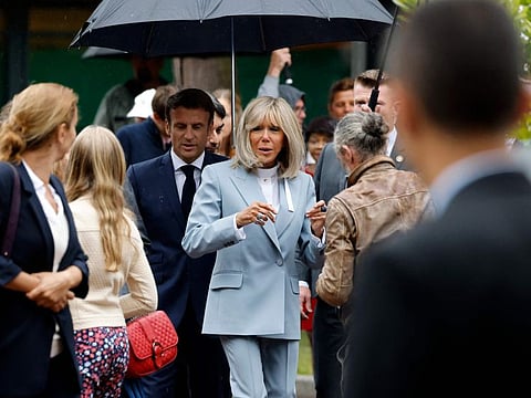 France's President Emmanuel Macron (CL) and his wife Brigitte Macron (CR) leave after casting their votes in the second stage of French parliamentary elections at a polling station in Le Touquet, northern France on June 19, 2022.