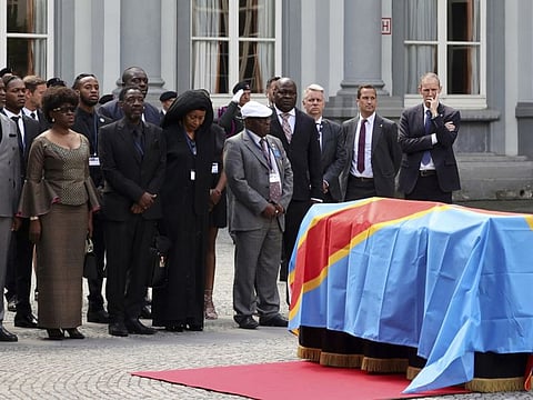 The children of Patrice Lumumba, from left, Roland, Juliana and Francois, stand next to the casket with the mortal remains of Patrice Lumumba during a ceremony at the Egmont Palace in Brussels, Monday, June 20, 2022.