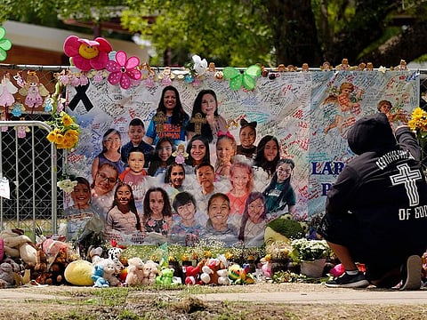 A mourner stops to pay his respects at a memorial at Robb Elementary School, created to honor the victims killed in the recent school shooting, June 9, 2022, in Uvalde, Texas.