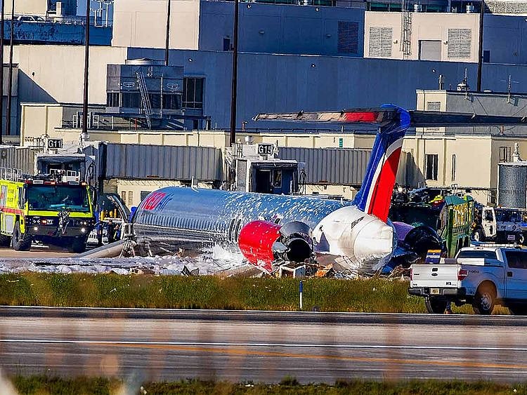 Firefighting units are seen next to a Red Air plane that caught fire after the front landing gear collapsed upon landing at Miami International Airport in Miami, after arriving from Santo Domingo, Dominican Republic.