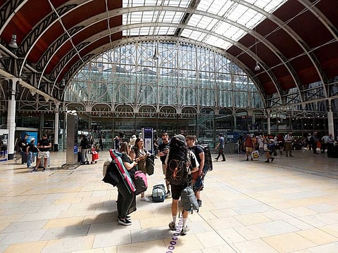 Travellers with camping equipment wait at Paddington Station in London the day after national rail strike 