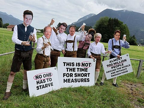Activists of the NGO ONE, wearing masks depicting G7 leaders, protest against the G7 summit to be held in the nearby Bavarian alpine resort hotel Elmau Castle, outside the main G7 media centre, in Garmisch-Partenkirchen, Germany June 24, 2022.   