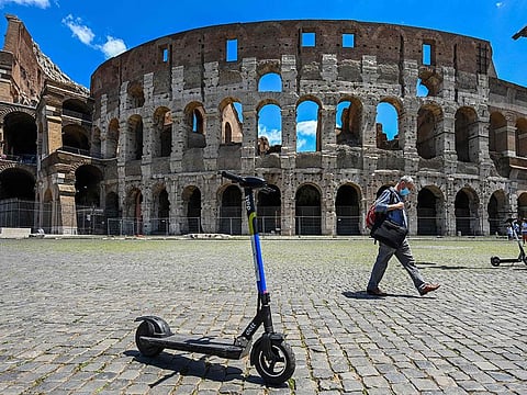 This file photo taken on June 22, 2020 shows shared electric scooters parked in front of the Coliseum monument in Rome. -