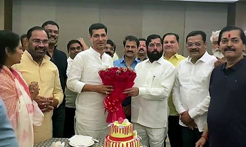 Rebel Shiv Sena leader Eknath Shinde presents a bouquet to party MLA Narendra Bhondekar as part of his birthday celebrations, as other MLAs look on, at Radisson Blu, in Guwahati on Sunday. 