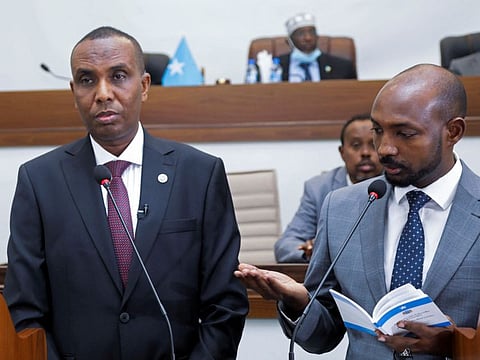 Somalia's Supreme Court Chairman Bashe Yousuf Ahmad swears in Prime Minister Hamza Abdi Barre after legislators voted to approve his appointment in Mogadishu, on June 25, 2022. 