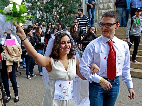 Two students at the American University of Beirut hold a symbolic civil marriage part of a campaign by The Civic Welfare League on the university campus, in Beirut, Lebanon, Wednesday, Feb. 13, 2013. In Lebanon, the question of civil marriage is a contentious issue mired in fierce religious and political debates.